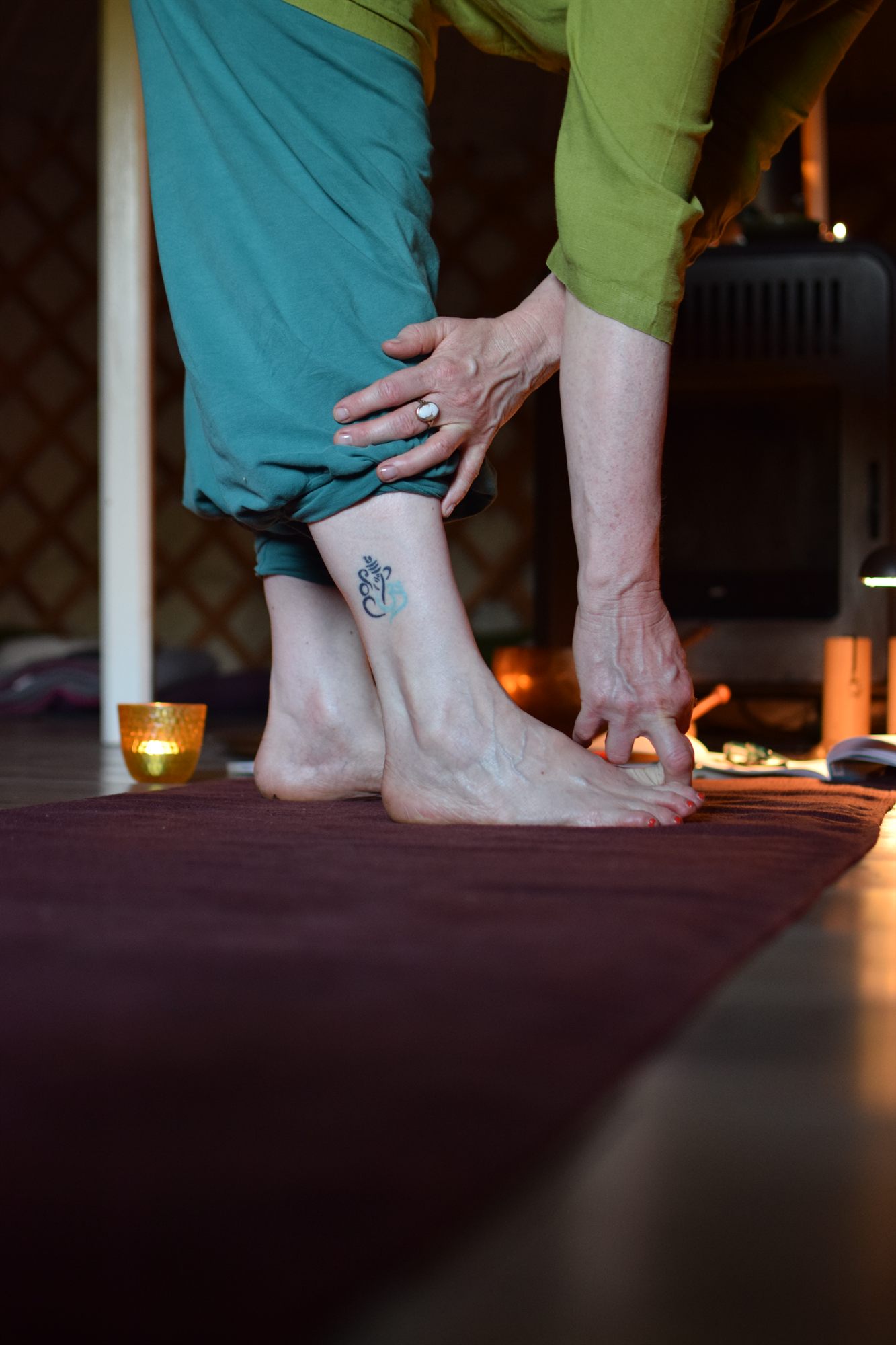 Voorwaartse buiging op de mat in de yurt, bij kaarslicht